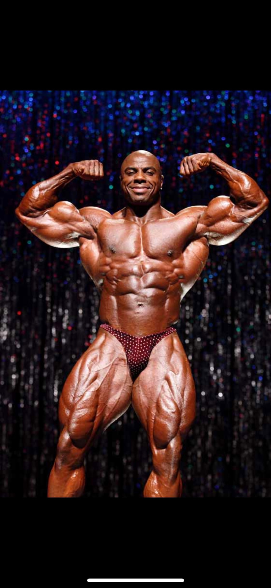 Toney Freeman hitting a front double-biceps pose on the professional bodybuilding stage