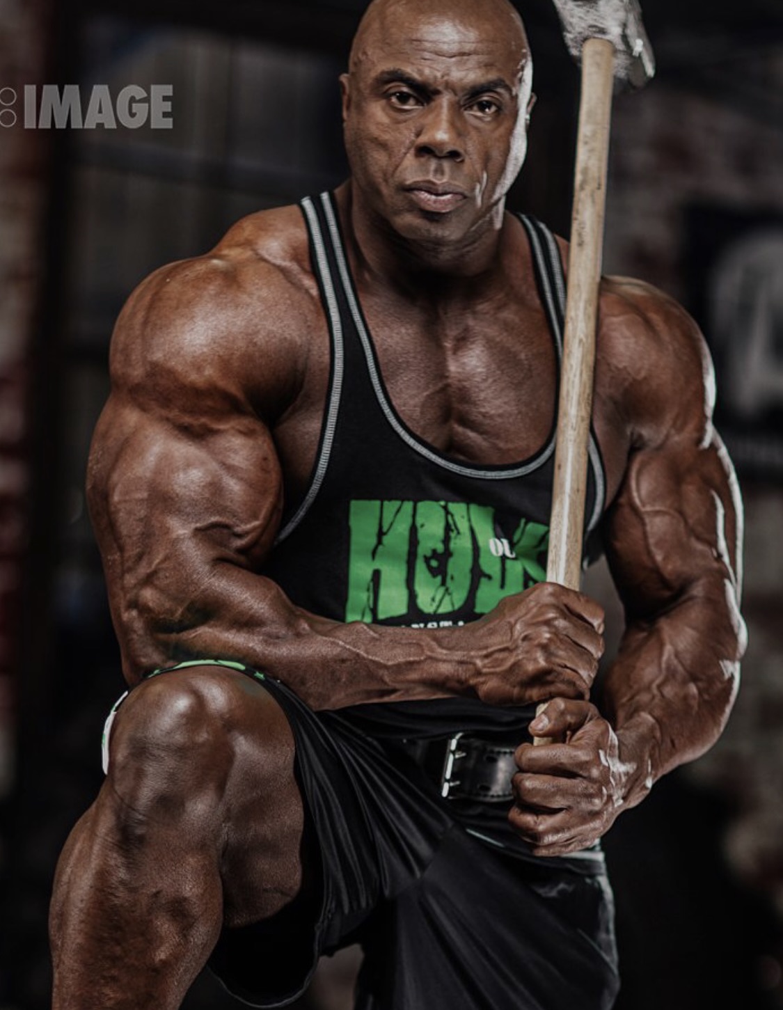 Toney Freeman gripping a sledgehammer during a conditioning session in a dark gym